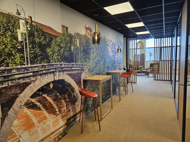 Espace de coworking avec mur photo représentant la ville de Toulouse